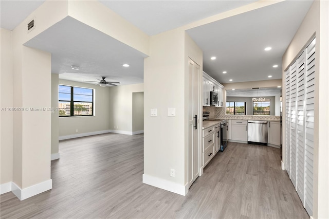 kitchen with white cabinets, appliances with stainless steel finishes, light wood-type flooring, and ceiling fan