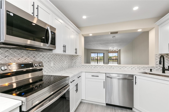 kitchen with decorative backsplash, sink, white cabinetry, and stainless steel appliances