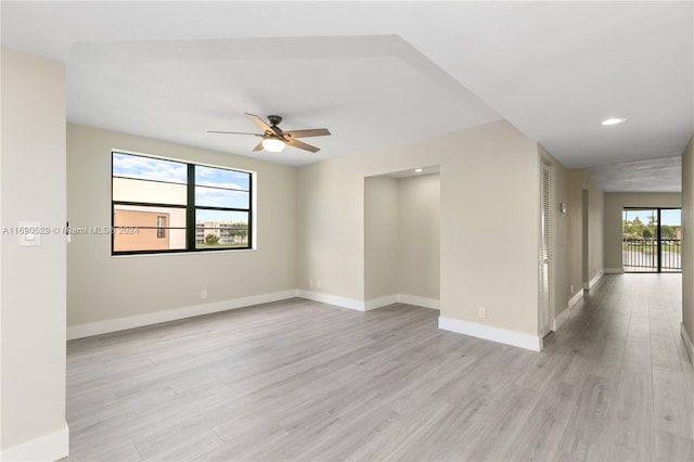 empty room featuring a wealth of natural light, light hardwood / wood-style flooring, and ceiling fan