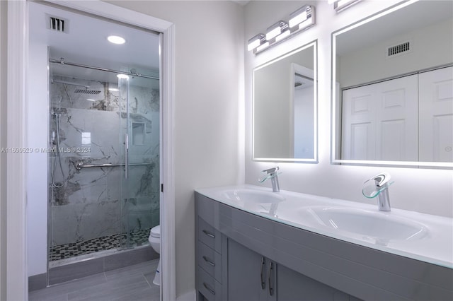 bathroom with a shower with door, vanity, and toilet