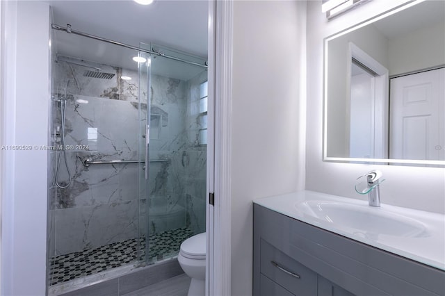 bathroom with vanity, toilet, and an enclosed shower