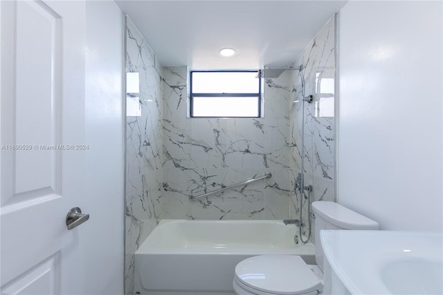 bathroom with tiled shower / bath combo and toilet