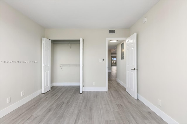 unfurnished bedroom featuring a closet and light wood-type flooring