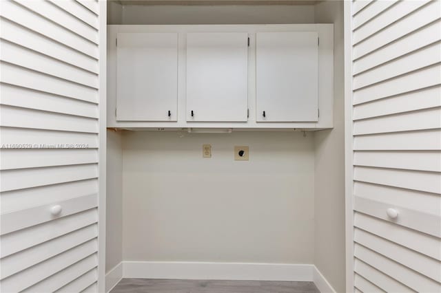 laundry room featuring hardwood / wood-style floors, electric dryer hookup, and cabinets