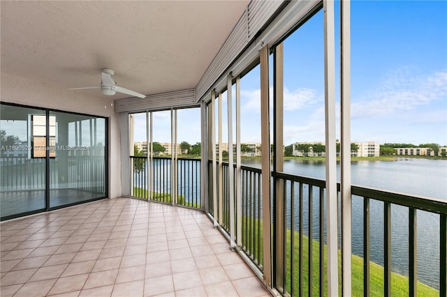 unfurnished sunroom with plenty of natural light, ceiling fan, and a water view