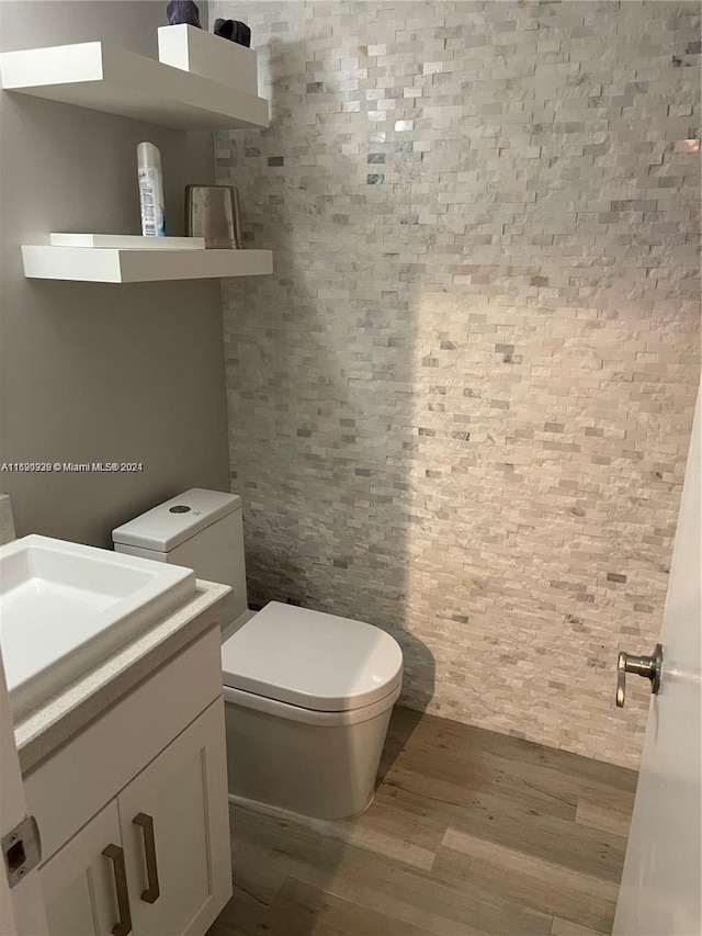 bathroom with hardwood / wood-style flooring, vanity, and toilet