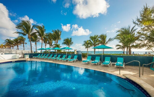 view of swimming pool with a water view and a patio area