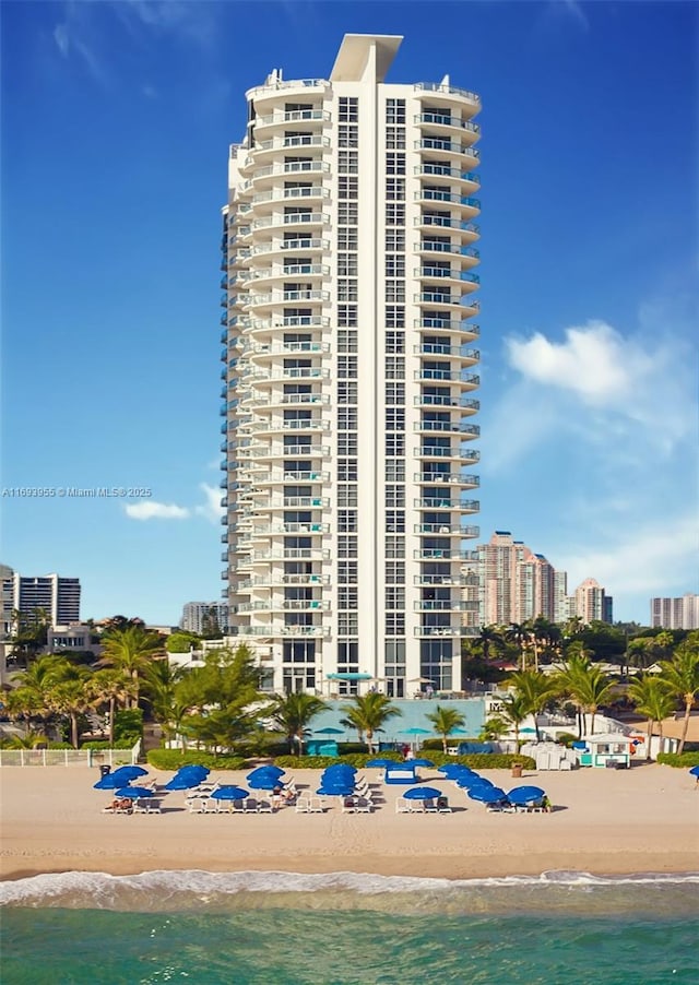 view of property with a beach view and a water view