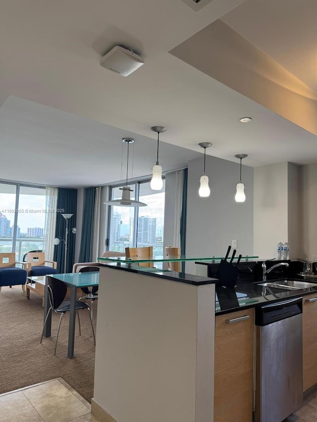 kitchen with sink, dishwasher, expansive windows, light carpet, and decorative light fixtures