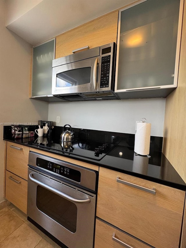 kitchen featuring light tile patterned flooring and appliances with stainless steel finishes