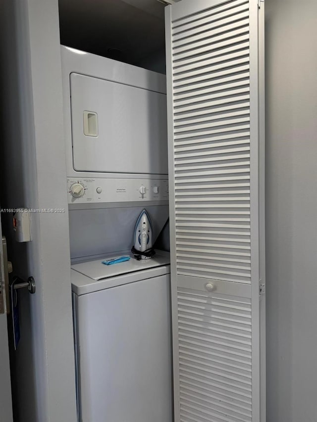 laundry room featuring stacked washer / drying machine