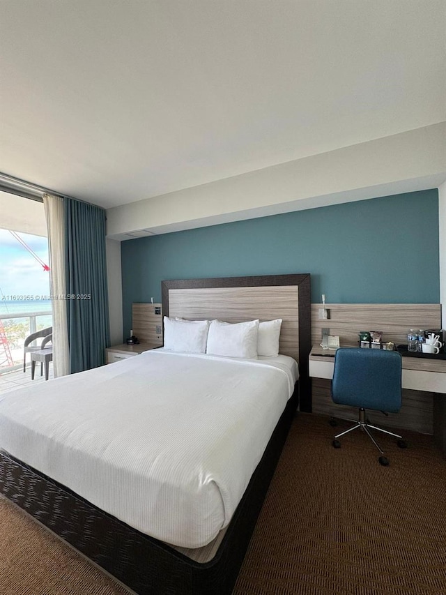 carpeted bedroom featuring access to outside and a wall of windows