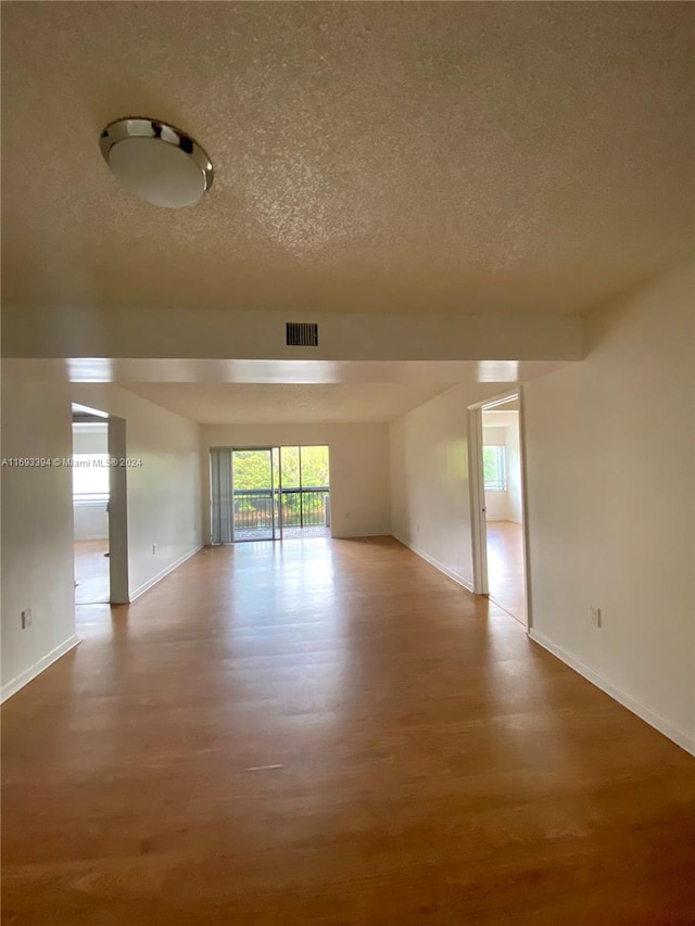 spare room featuring wood-type flooring and a textured ceiling