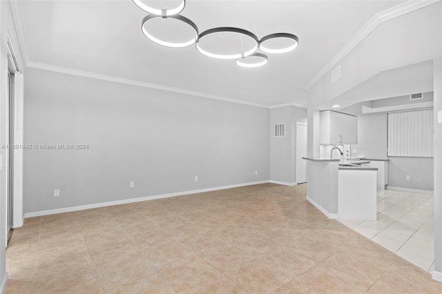 unfurnished living room with light tile patterned floors, ornamental molding, and sink