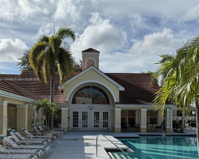 view of swimming pool featuring french doors and a patio