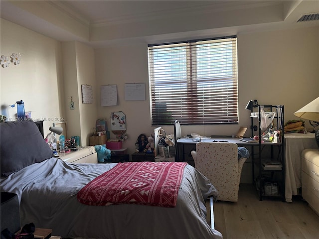 bedroom featuring crown molding and light hardwood / wood-style floors