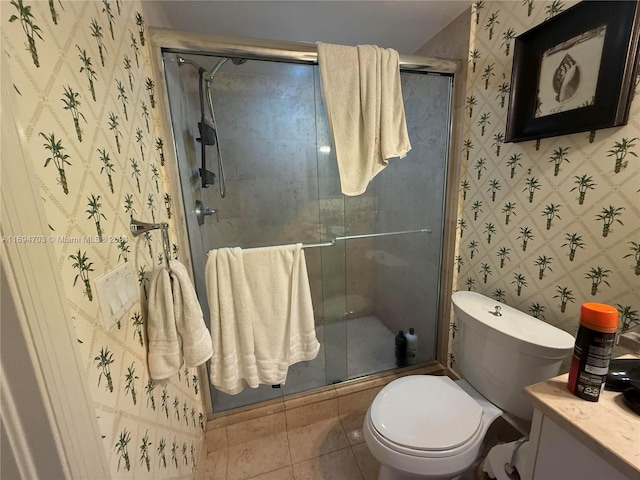 bathroom featuring tile patterned flooring, vanity, toilet, and a shower with shower door