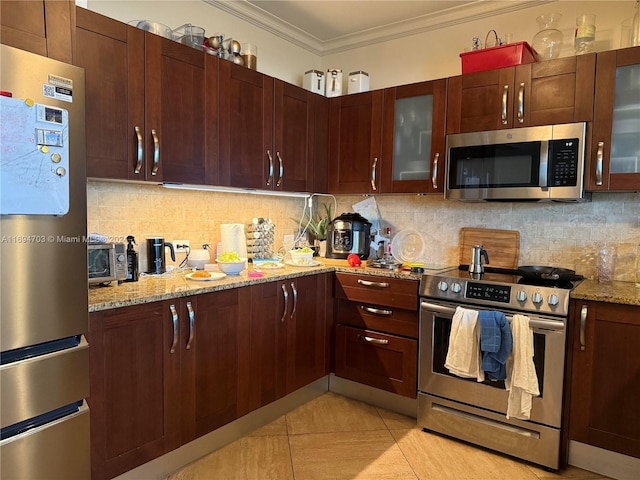 kitchen with light stone countertops, light tile patterned floors, stainless steel appliances, and ornamental molding