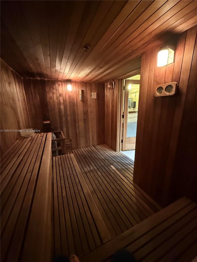 view of sauna with hardwood / wood-style floors, wooden ceiling, and wooden walls