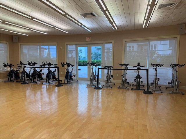 exercise room with french doors and light hardwood / wood-style flooring