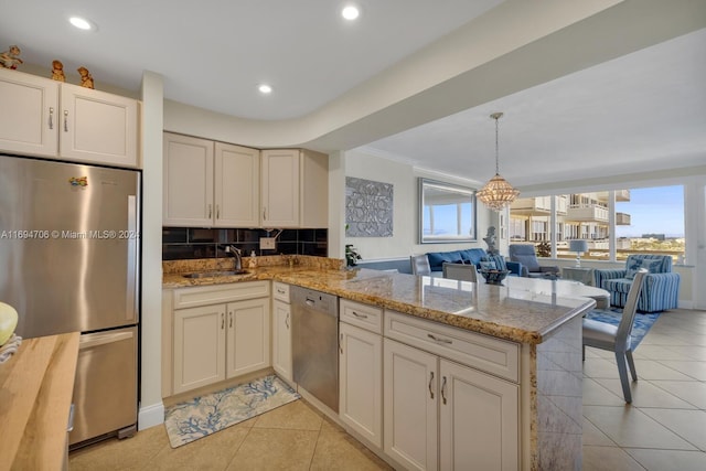 kitchen with kitchen peninsula, sink, light tile patterned flooring, and stainless steel appliances