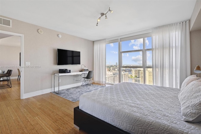 bedroom featuring hardwood / wood-style floors and rail lighting