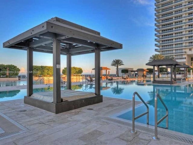 pool at dusk with a patio