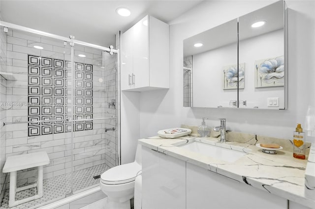 bathroom featuring tile patterned flooring, vanity, an enclosed shower, and toilet