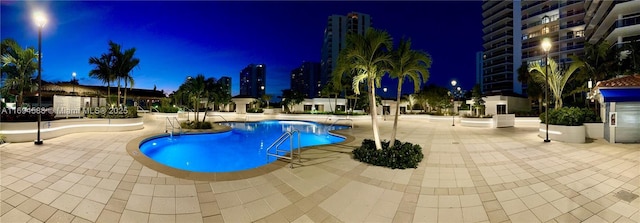 pool at twilight with a patio