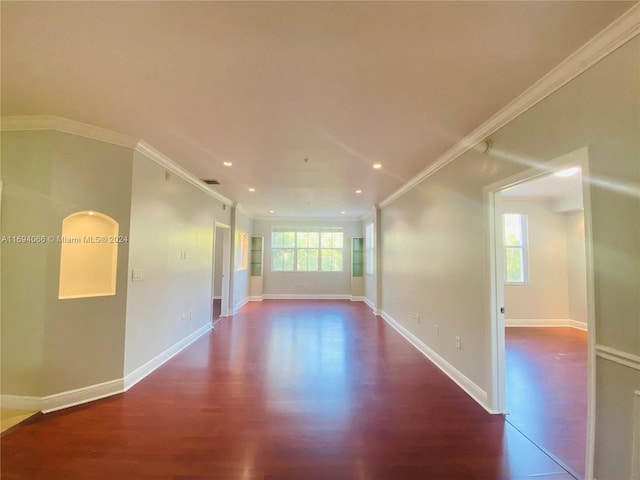 spare room featuring crown molding and dark wood-type flooring