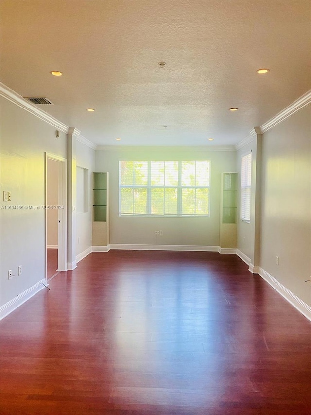 unfurnished room with dark wood-type flooring, a textured ceiling, and ornamental molding