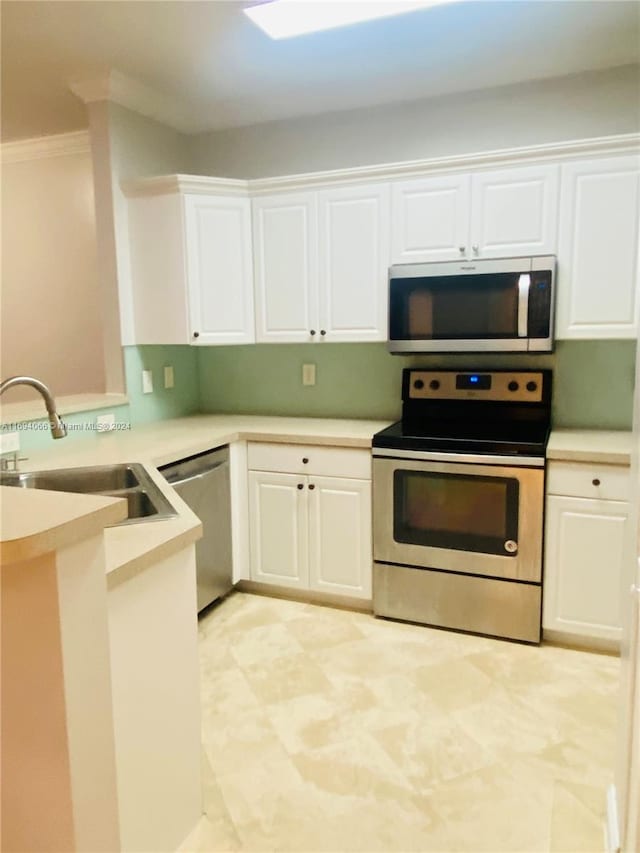 kitchen with crown molding, white cabinetry, sink, and stainless steel appliances