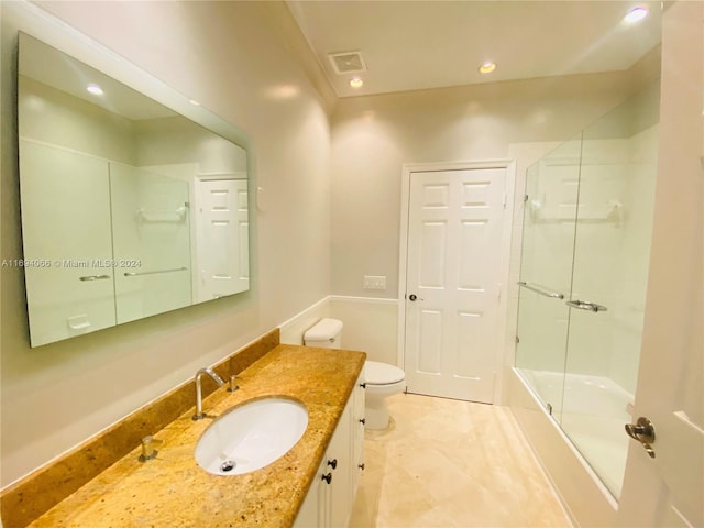 full bathroom with combined bath / shower with glass door, vanity, and toilet