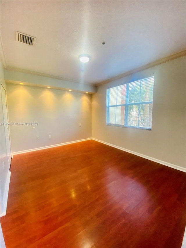 spare room with hardwood / wood-style flooring and ornamental molding