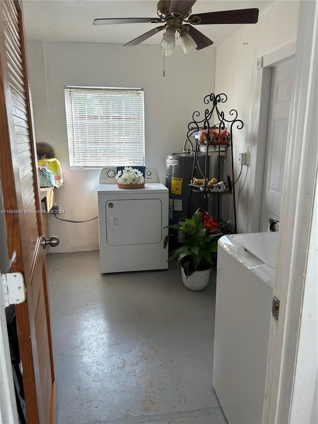 clothes washing area featuring ceiling fan, washing machine and dryer, and water heater