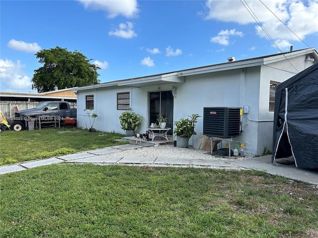 back of property with a yard and cooling unit