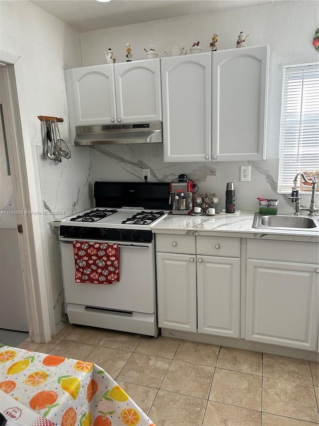 kitchen with white cabinetry, white range with gas stovetop, sink, and light tile patterned floors