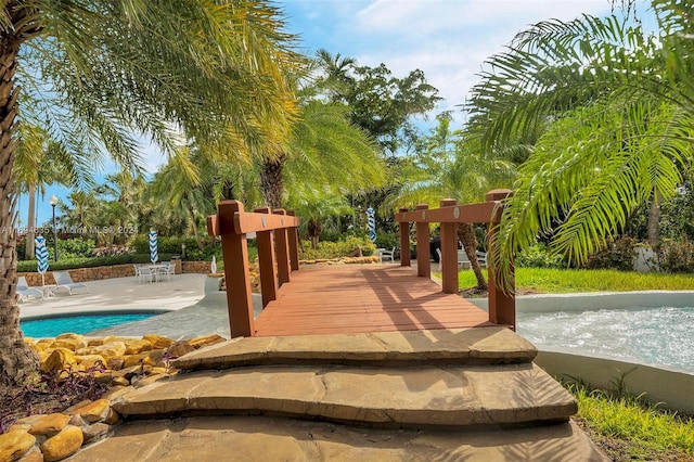 view of property's community with a swimming pool and a patio