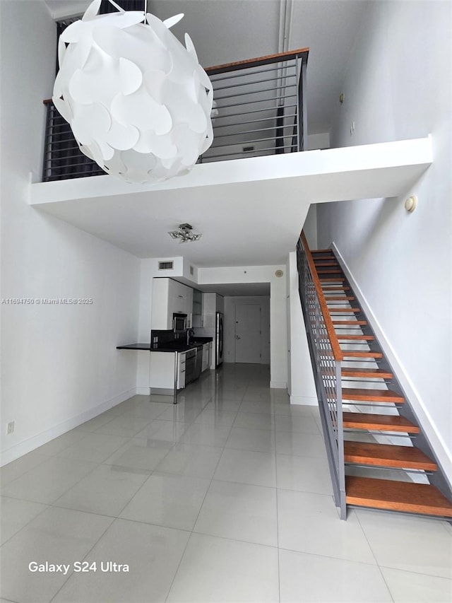 stairway featuring tile patterned flooring and baseboards