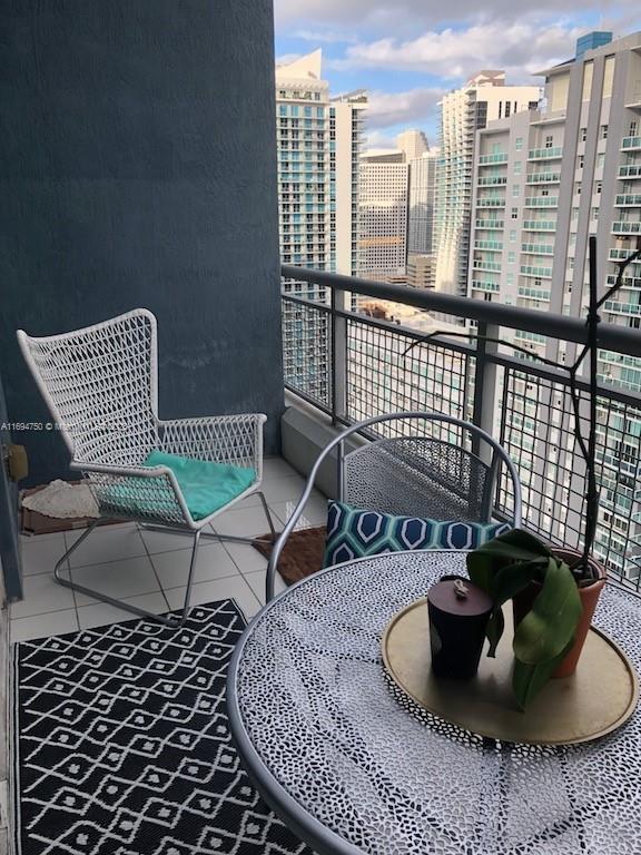 balcony with outdoor dining space and a view of city