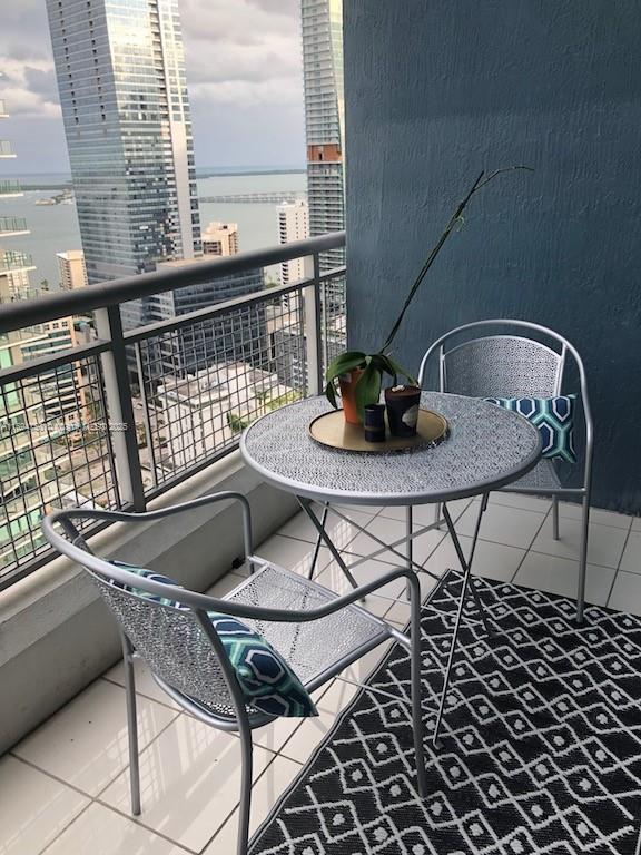 balcony with a water view and a view of city