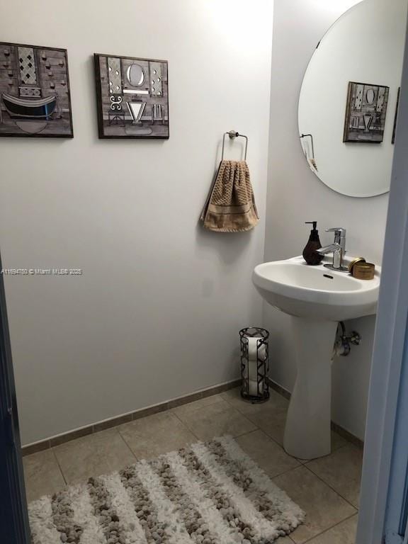 bathroom with baseboards and tile patterned flooring