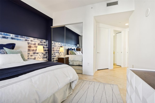 bedroom with light tile patterned floors and a closet