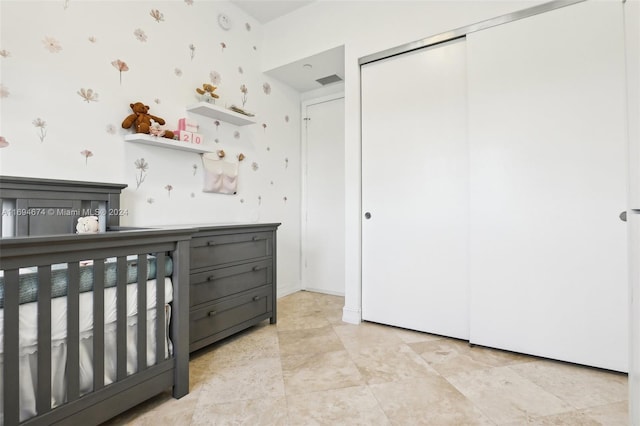 bedroom with a crib and a closet