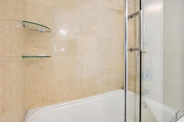 bathroom with bath / shower combo with glass door