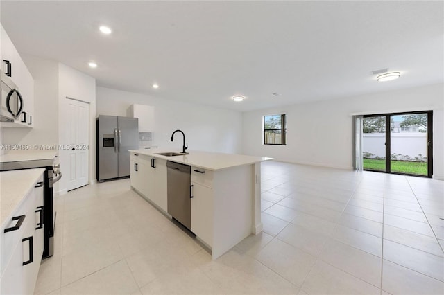 kitchen featuring stainless steel appliances, a kitchen island with sink, sink, light tile patterned floors, and white cabinets