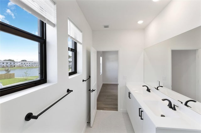 bathroom featuring hardwood / wood-style floors, vanity, and a water view