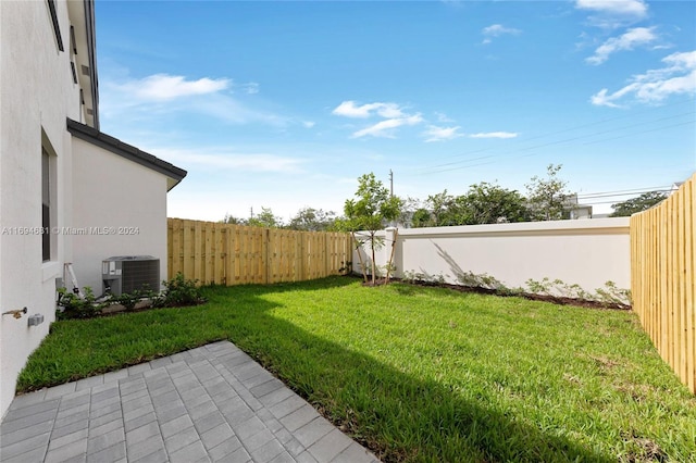 view of yard with central air condition unit and a patio area