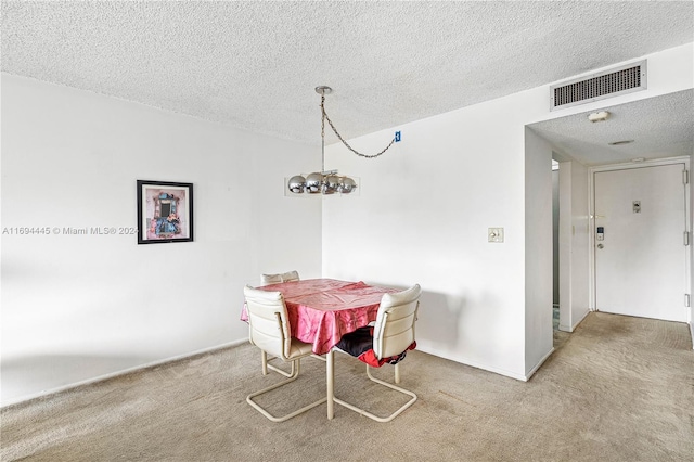 carpeted dining room featuring a textured ceiling