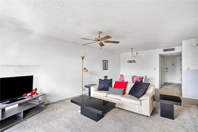 carpeted living room with ceiling fan with notable chandelier and a textured ceiling